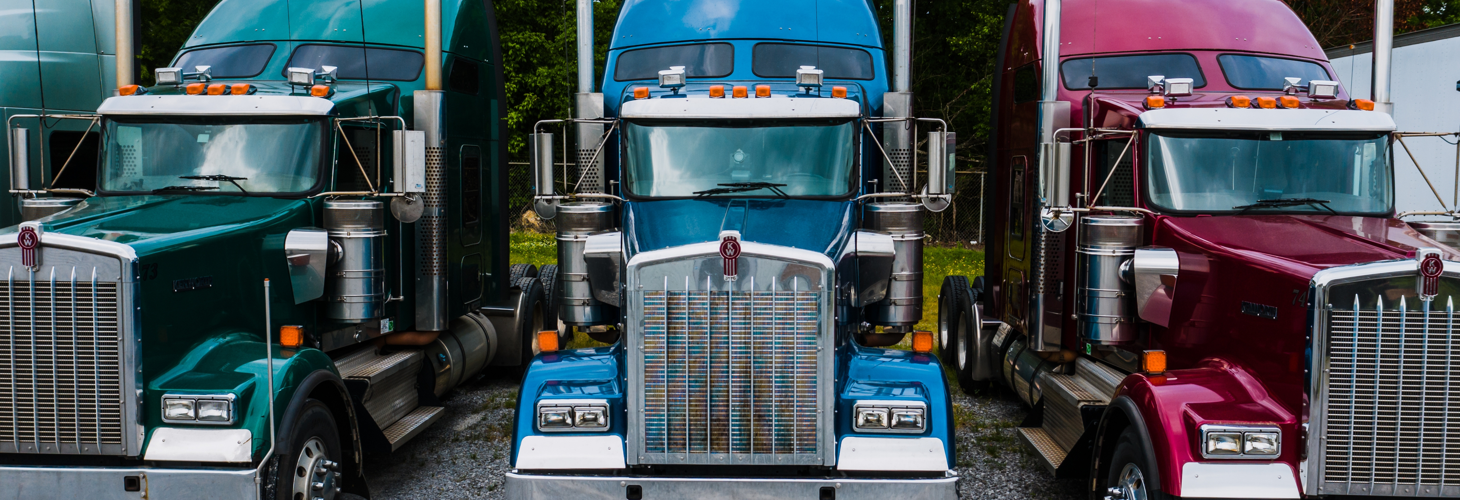 three semi trucks parked in a row