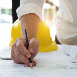 Contractor writing on blueprint