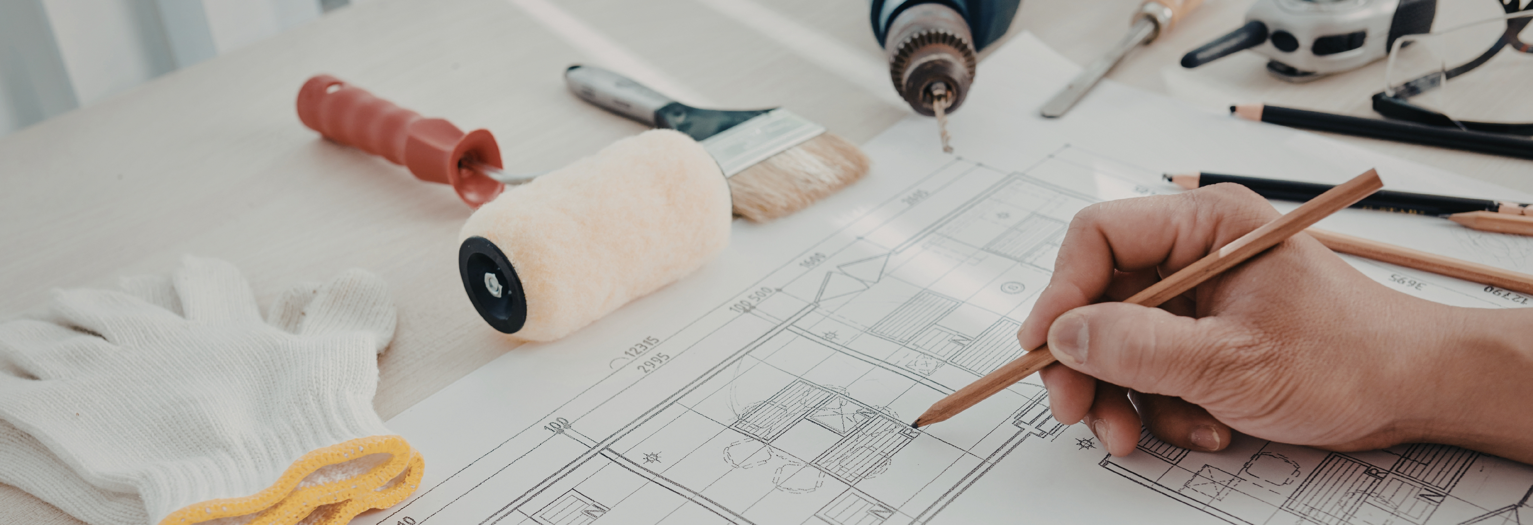 house floor plan with a hand holding a pencil